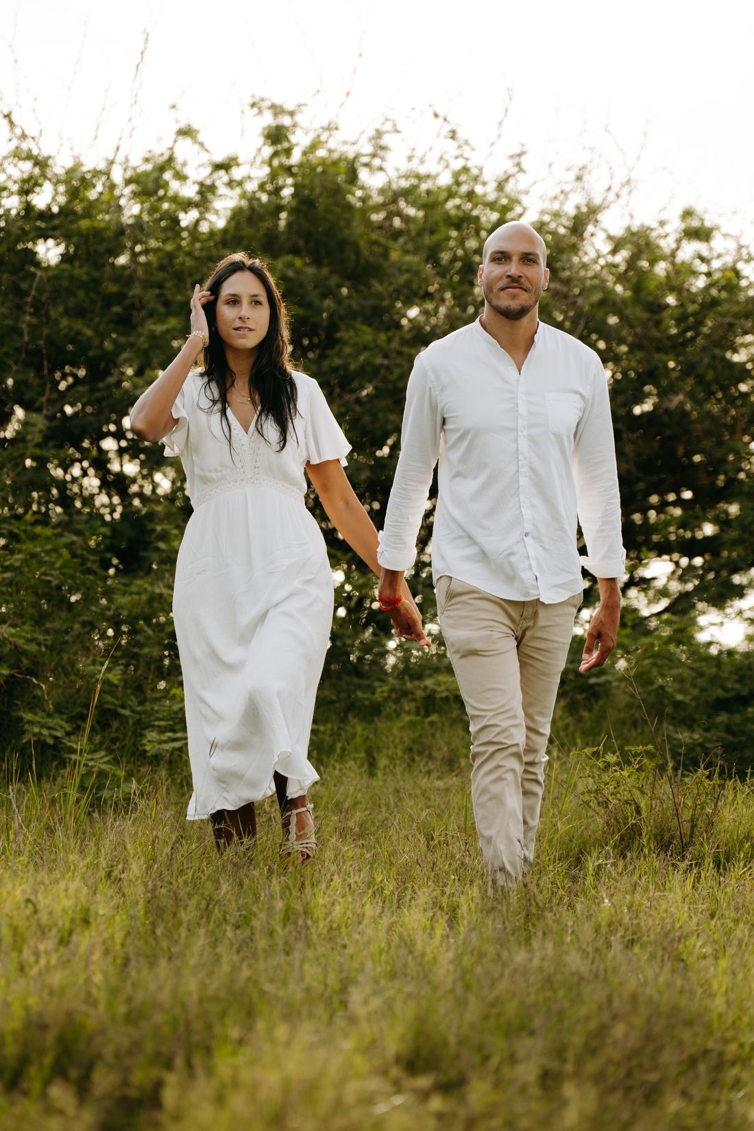 Aurélie et Adrien marchent main dans la main dans les herbes hautes